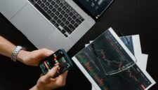 Ilustrasi kalender yang menandai tanggal-tanggal penting di bursa saham, menggambarkan momen krusial bagi investor untuk memantau jadwal pembagian dividen perusahaan. Tangan yang sedang memegang grafik saham menunjukkan analisis data yang cermat sebelum mengambil keputusan investasi.