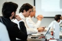 Suasana rapat dewan direksi yang menunjukkan diskusi transparan dan pengambilan keputusan yang akuntabel, merefleksikan pentingnya tata kelola perusahaan yang baik dalam menjaga kepercayaan investor. Gambar ini menggambarkan komitmen manajemen terhadap praktik bisnis yang etis dan bertanggung jawab.