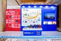 A display booth featuring Valvoline GEELY collaboration, showcasing co-developed lubricants and a timeline of their partnership, with product bottles arranged on a central table.