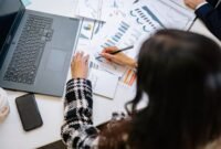 Seorang investor tengah menganalisis grafik dan data keuangan kompleks pada layar, mencerminkan proses mendalam dalam memahami valuasi saham sebelum mengambil keputusan investasi. Pemahaman fundamental adalah kunci utama untuk investasi yang cerdas.