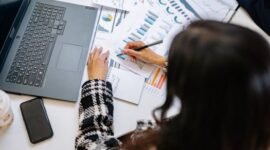 Seorang investor tengah menganalisis grafik dan data keuangan kompleks pada layar, mencerminkan proses mendalam dalam memahami valuasi saham sebelum mengambil keputusan investasi. Pemahaman fundamental adalah kunci utama untuk investasi yang cerdas.
