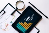 Ilustrasi tumpukan laporan tahunan dengan laptop yang menampilkan grafik data, mencerminkan perpaduan antara format tradisional dan digital dalam penyajian informasi perusahaan. Desain modern pada laporan menunjukkan komitmen perusahaan terhadap transparansi dan komunikasi yang efektif kepada para pemangku kepentingan.