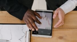 Seorang investor dengan cermat menganalisis pergerakan grafik saham di layar komputer, merefleksikan dinamika pasar yang terus berubah. Gambar ini menangkap esensi pengambilan keputusan yang hati-hati di tengah fluktuasi indeks harga saham.