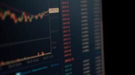 Seorang investor tengah menganalisis data saham di layar digital yang menampilkan grafik serta angka-angka keuangan. Gambar ini merepresentasikan pentingnya akses terhadap informasi yang transparan dan akurat bagi para pelaku pasar modal.