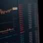 Seorang investor tengah menganalisis data saham di layar digital yang menampilkan grafik serta angka-angka keuangan. Gambar ini merepresentasikan pentingnya akses terhadap informasi yang transparan dan akurat bagi para pelaku pasar modal.