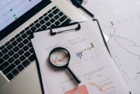 Seorang profesional tengah menganalisis laporan keuangan dan grafik saham, merepresentasikan proses mendalam dalam analisis fundamental untuk mengambil keputusan investasi yang cerdas. Fokus pada data dan kinerja perusahaan adalah kunci untuk investasi jangka panjang yang sukses.