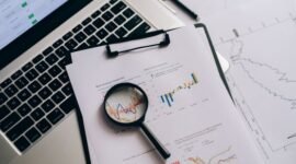 Seorang profesional tengah menganalisis laporan keuangan dan grafik saham, merepresentasikan proses mendalam dalam analisis fundamental untuk mengambil keputusan investasi yang cerdas. Fokus pada data dan kinerja perusahaan adalah kunci untuk investasi jangka panjang yang sukses.