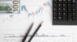Grafik dan diagram keuangan pada layar komputer menunjukkan fluktuasi kinerja emiten di bursa saham. Memahami data ini membantu kita melihat bagaimana perusahaan besar memengaruhi perekonomian dan kehidupan sehari-hari.