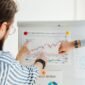 Seorang investor tengah menganalisis grafik kinerja keuangan emiten di layar komputer, menunjukkan pentingnya data dalam membuat keputusan investasi yang tepat di tengah dinamika pasar.