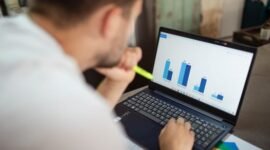 Seorang pebisnis sedang menganalisis data keuangan yang ditampilkan pada grafik pertumbuhan, menunjukkan pentingnya evaluasi cermat terhadap rencana penambahan modal sebuah perusahaan untuk memahami potensi dampaknya di masa depan.