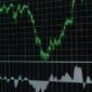 Grafik dan data digital yang ditampilkan di layar bursa efek ini melambangkan arus informasi transparan yang penting bagi setiap investor. Keterbukaan data memungkinkan pengambilan keputusan investasi yang tepat.