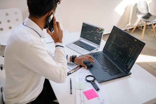 Seorang pebisnis tengah menganalisis grafik finansial di laptop, menunjukkan aktivitas riset mendalam sebelum membuat keputusan investasi. Proses ini merefleksikan pentingnya analisis fundamental dalam memilih saham untuk tujuan jangka panjang.